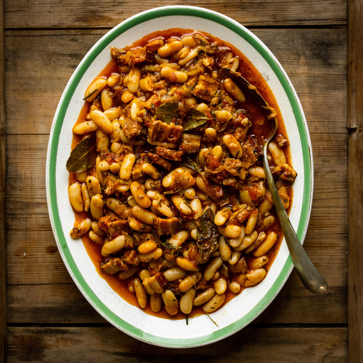 Baked winter beans with smoked bacon, bay, tomato and rosemary