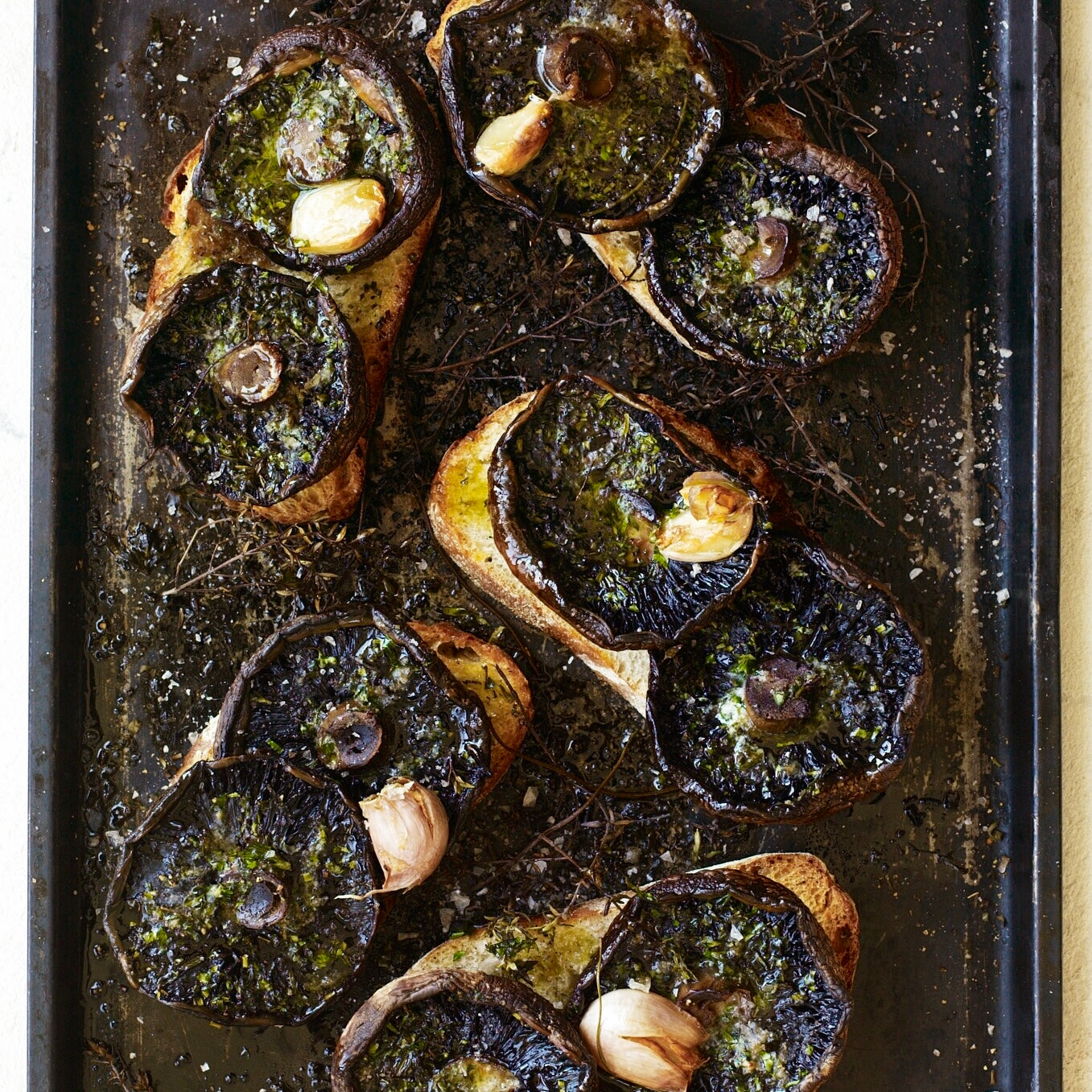 Mushrooms baked on toast with garden herbs, butter & garlic