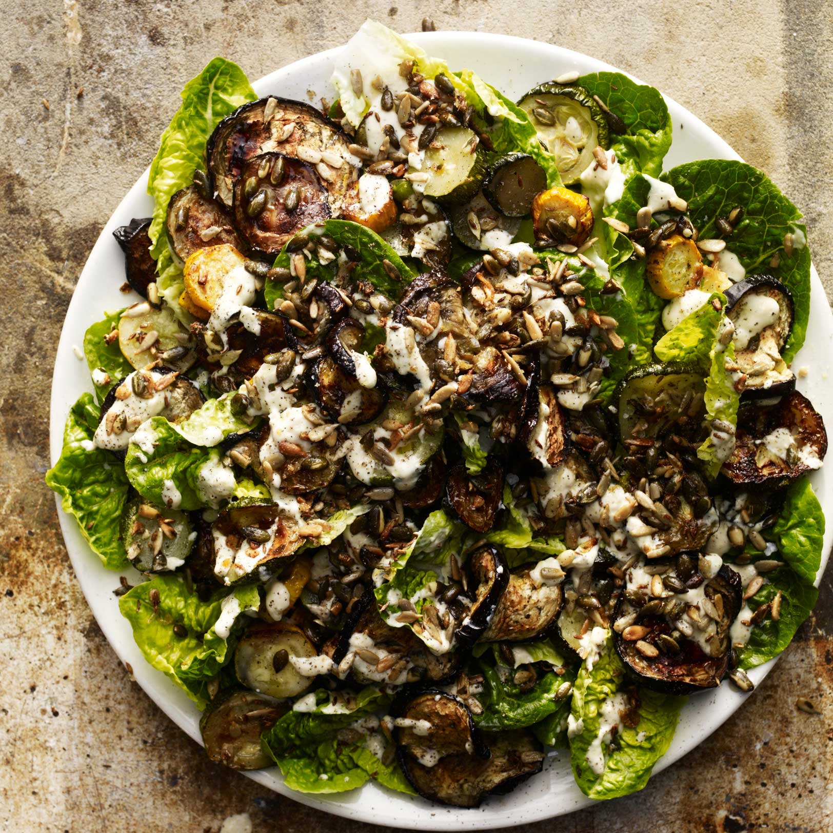 Aubergine, courgette and lettuce salad with toasted seeds, mint and tahini dressing