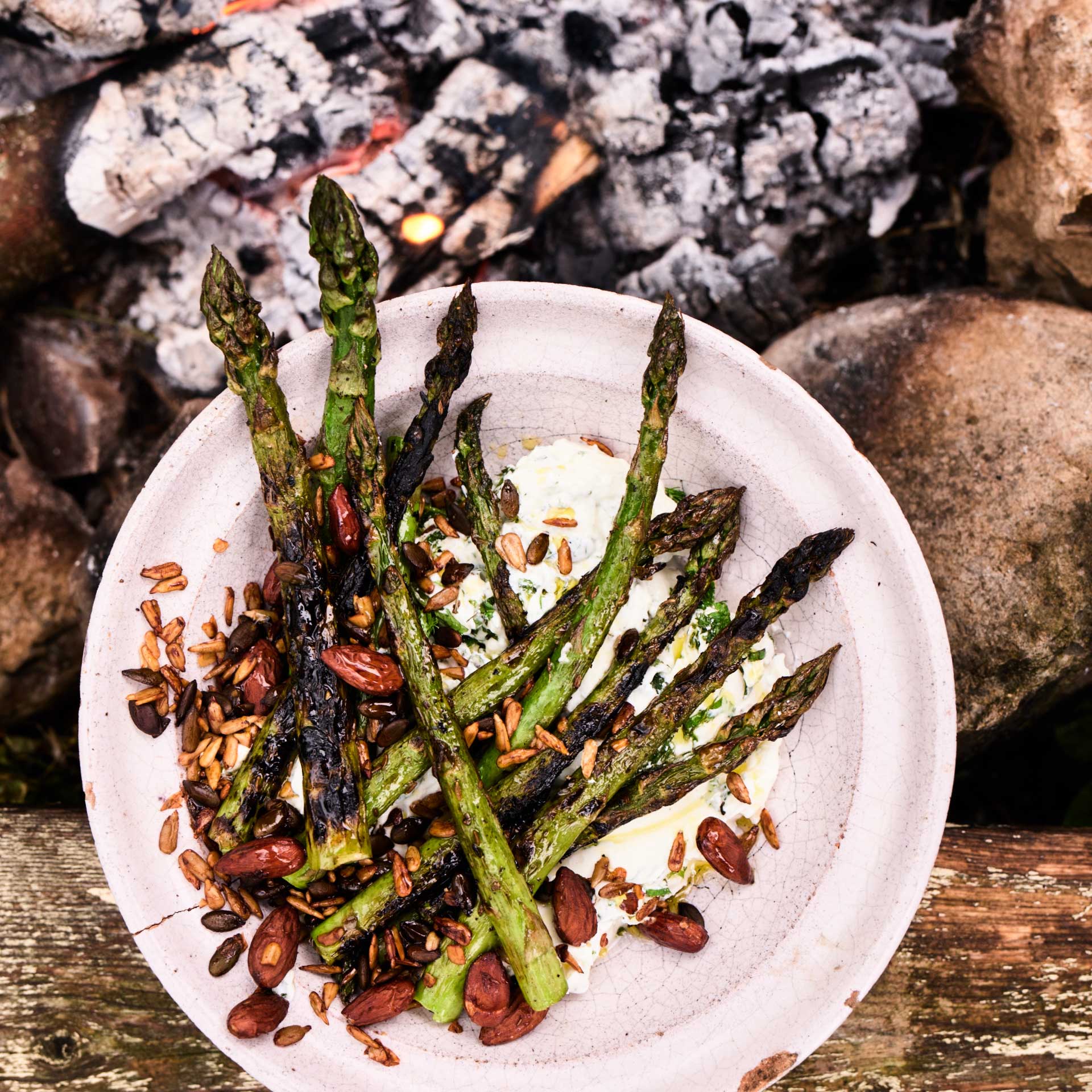 Asparagus cooked on the fire with labneh, mint, almonds and seeds