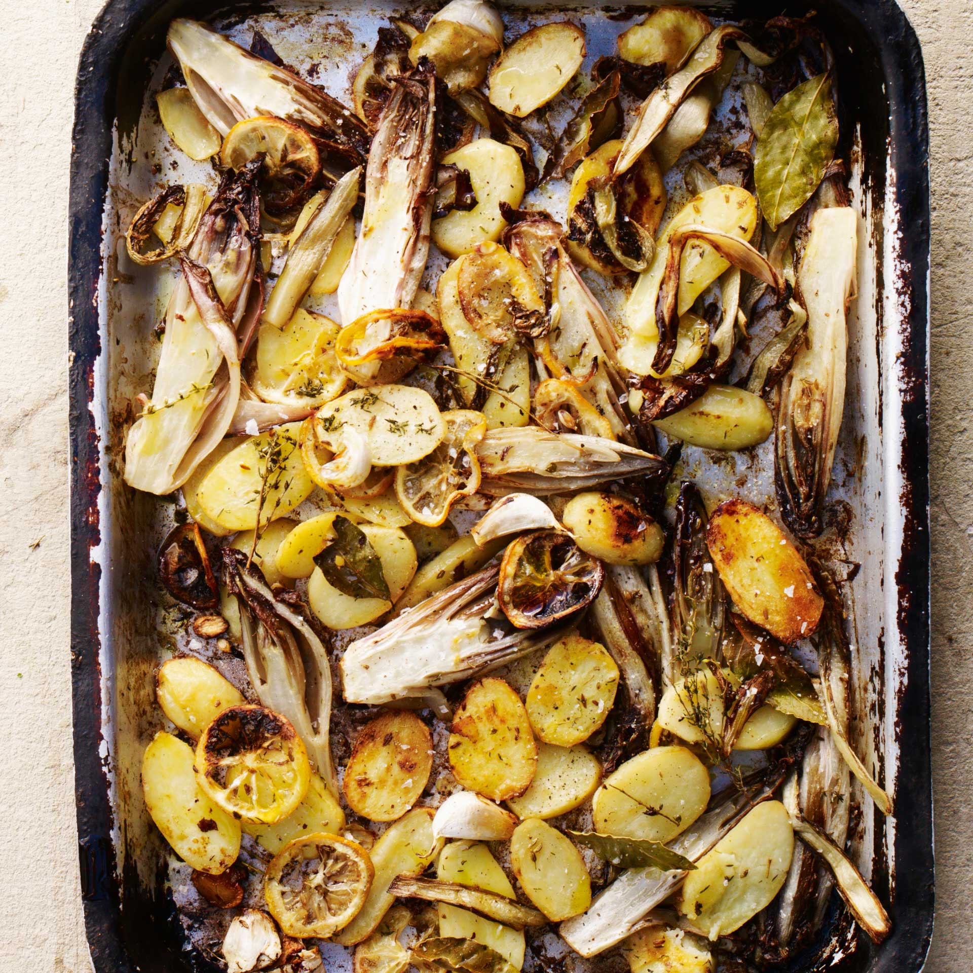 Baked chicory and potatoes with lemon, butter, thyme, bay and garlic