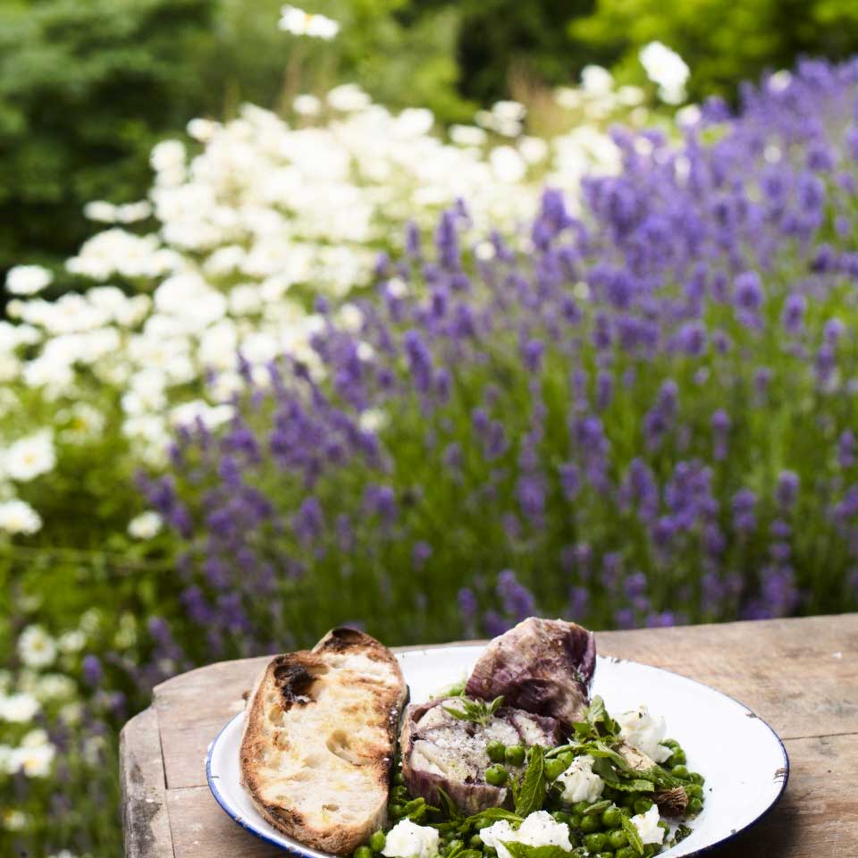 Baked wet garlic with lemon, marjoram, peas and goat’s cheese