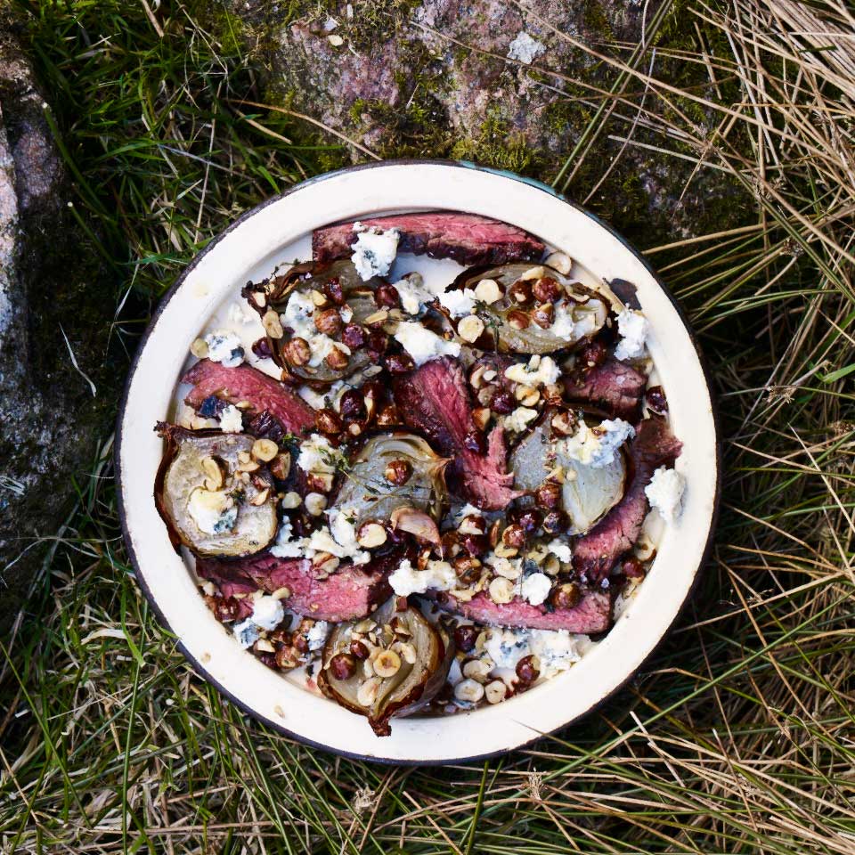 Skirt steak and ember-baked onions with blue cheese and hazelnuts