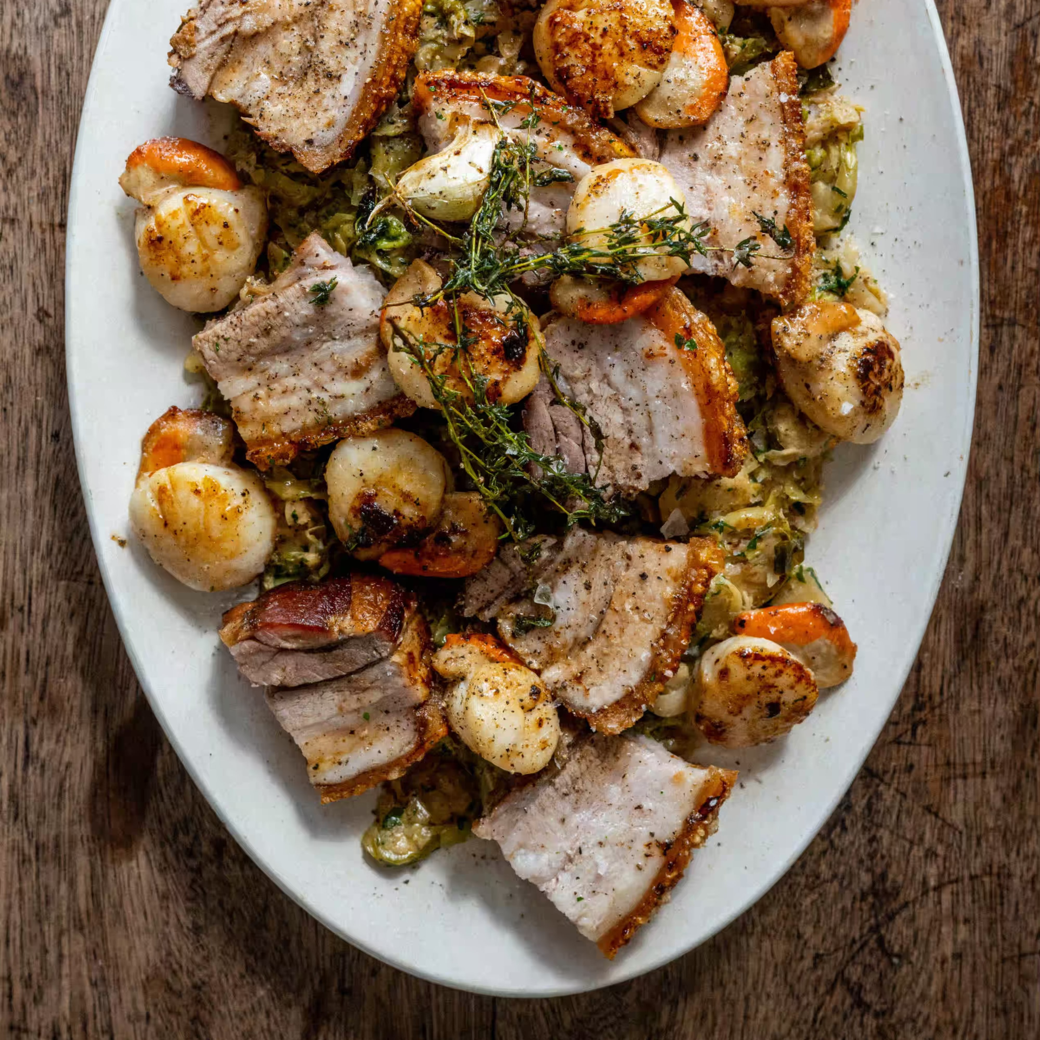 Seared scallops with creamed sprouts, roast pork belly and crackling