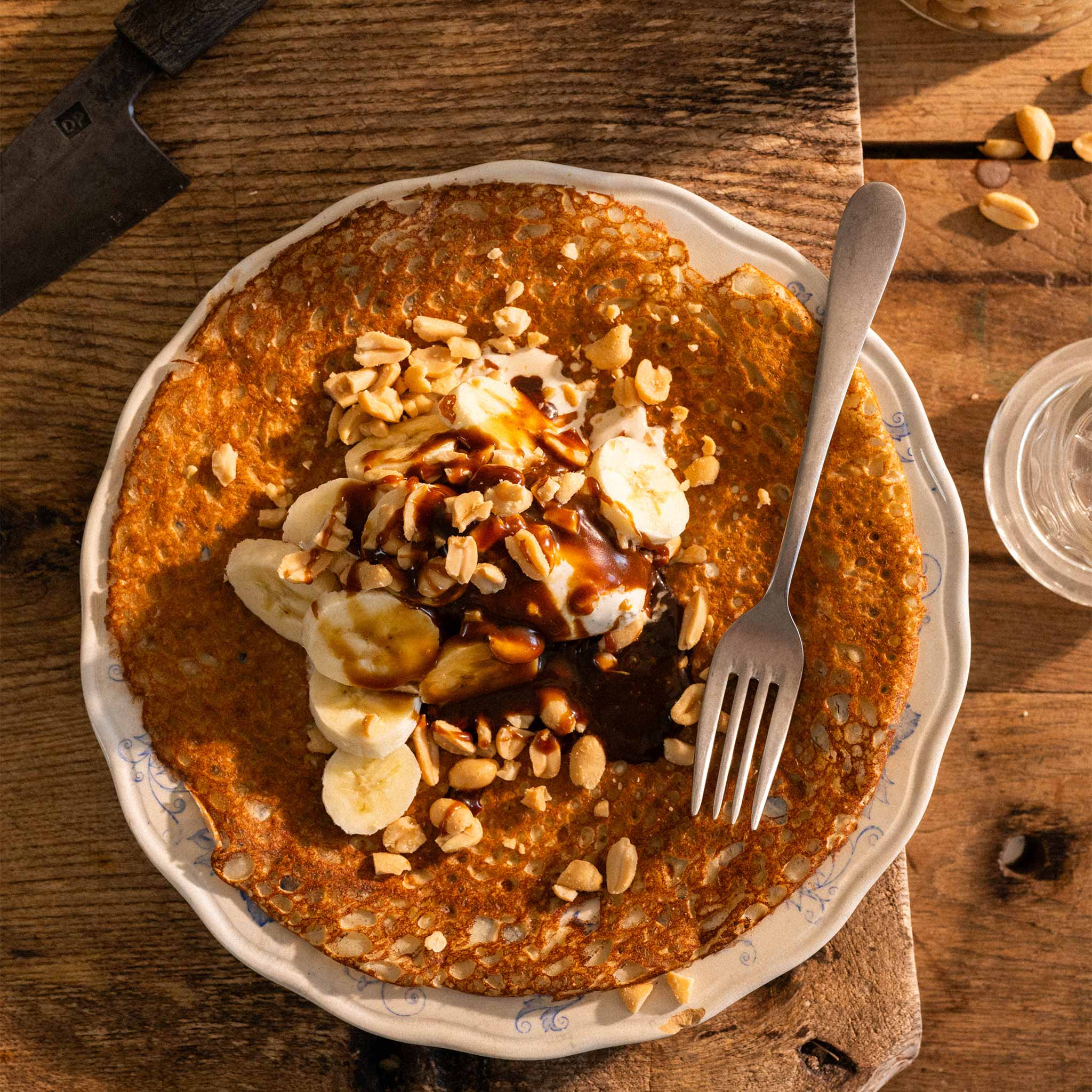 Buckwheat pancakes with ice cream, salted toffee sauce, bananas and peanuts