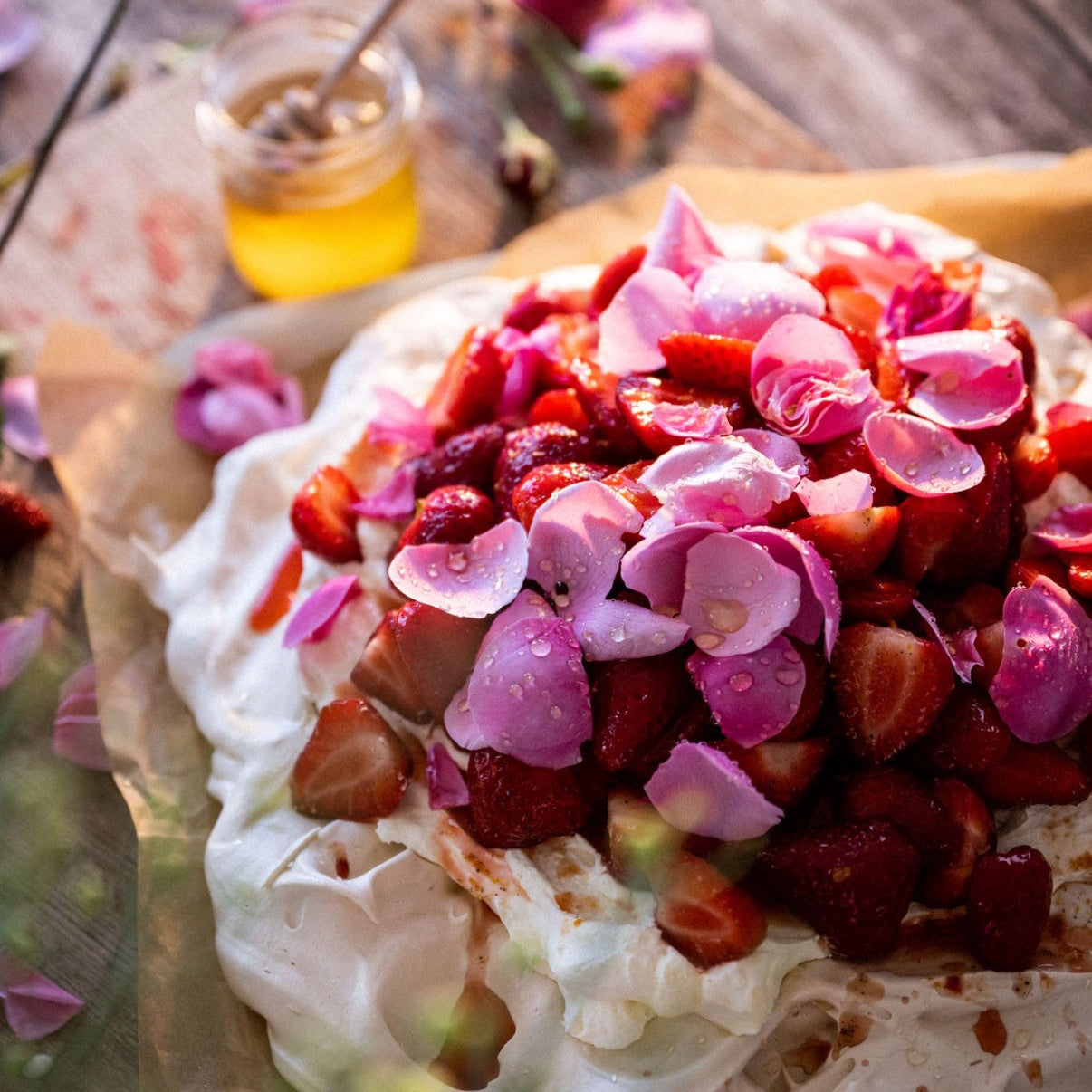 Pavlova with strawberries, cardamom, honey and rose petals